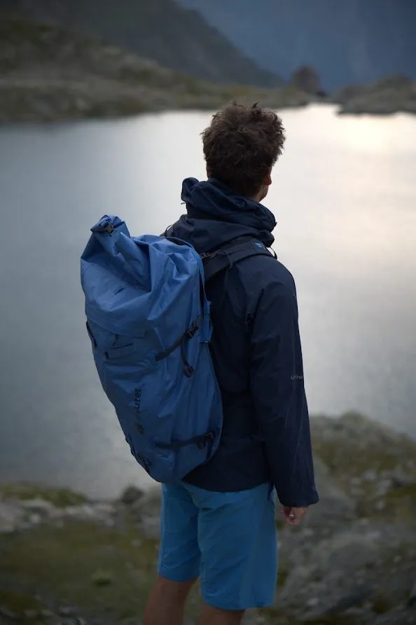 Thilo mit blauem Deuter-Rucksack an einem Bergsee