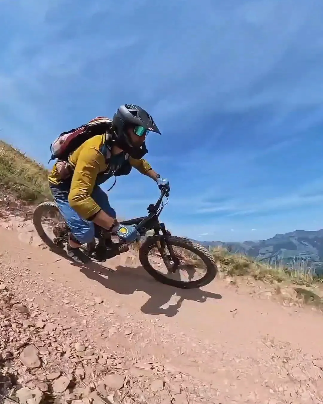 Mountainbiker in gelber Jacke in voller Schräglage auf dem Kirchberg Trail